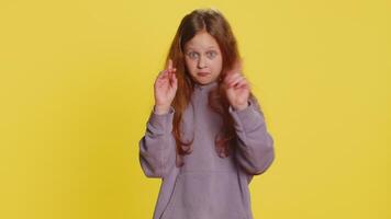 Don't want to look at this, awful. Afraid shocked preteen child girl kid closing eyes with hand showing stop gesture, confused shy scared reject to watch. Teen children isolated on yellow background video