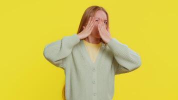 Don't want to look at this, awful. Afraid shocked Caucasian middle-aged woman closing eyes with hand showing stop gesture, confused shy scared reject to watch. Adult girl isolated on yellow background video