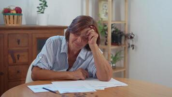 Senior woman counting coins and feeling stressed at home video