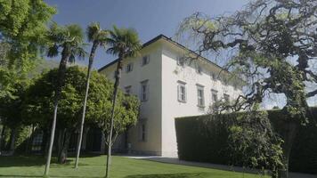 Elegant white villa in a lush garden setting. Action video