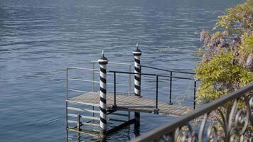 Small wooden pier gently floating on calm lake water. Action video