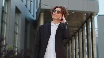 Portrait of Caucasian puzzled businessman professional standing outdoors deep in thoughts thinking recollecting memory creating plan. Handsome man in formalwear and sunglasses on downtown city street. video