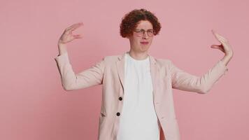 Disappointed Caucasian curly haired man in jacket showing blah blah nonsense gesture with hands, not interested in conversation, gossips, empty promises, rumors, liars. Guy isolated on pink background video