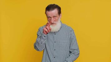 I am watching you. Confident attentive senior old man grandpa pointing at eyes and camera, show I am watching you gesture, spying on someone. Elderly bearded grandfather isolated on yellow background video