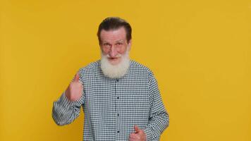 Like. Senior man raises thumbs up agrees with something or gives positive reply recommends advertisement likes good idea feedback celebrating success victory. Grandfather isolated on yellow background video