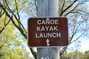 Canoe Kayak Launch Brown Sign with Arrow on Pole at Park photo