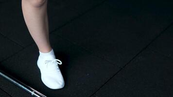 girl in white sneakers develops ankle and hip joints. hip joint circular movements of the leg video