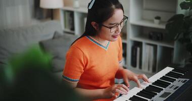 Handheld high angle view shot, Woman's hands are practicing playing the piano keyboard with relaxation and happiness in the living room. Relaxing holiday at home video