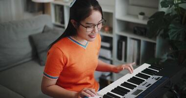 Handheld high angle view shot, Determined young woman is practicing her keyboard alone and enjoys a peaceful moment with music. video