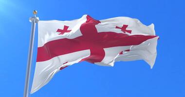 Flag of Georgia waving at wind in slow in blue sky, loop video