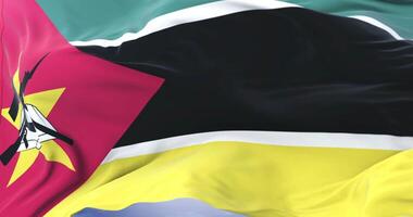 Mozambique flag waving at wind in slow in blue sky, loop video