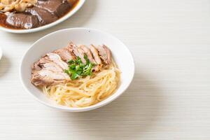 dried noodles with stewed duck in white bowl - Asian food style. photo