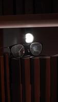 A pair of glasses sits on top of a bookshelf video