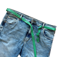Jeans and green measuring tape instead of a belt on a transparent background. Concept of weight loss, diet, detox, thin waist. Copy space for text png