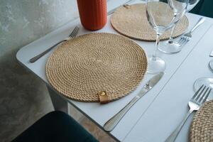 A beautifully set table featuring an elegant place mat, polished silverware arranged neatly, and exquisite wine glasses positioned perfectly on it, creating a sophisticated dining experience photo