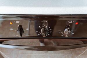 This image features a closeup view of a sleek black oven that is equipped with a prominent red light located at the top, enhancing its visibility and giving it a modern touch photo