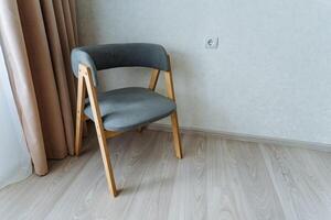In a cozy room, warm natural light fills the space, illuminating a charming wooden chair on a polished floor by a sunny window, creating a perfect atmosphere for relaxation photo