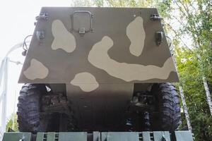 This image features the rear section of a military vehicle, which is designed with a distinct camouflage pattern, suitable for blending into various terrains and environments photo