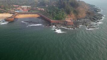 Fort walls and green tropical trees at Goa's ocean edge video
