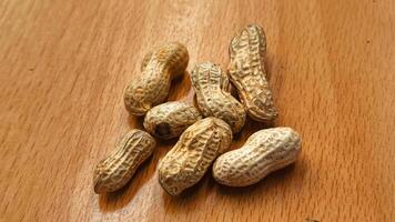 Roasted peanuts in shells on a rustic wooden table healthy snack food photo