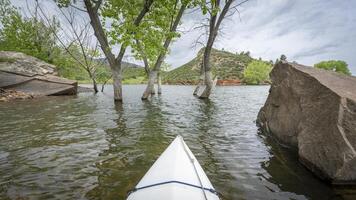 spring kayaking canoeing on Horsetooth Reservoir at foothills of Rocky Mountains near Fort Collins, Colorado - POV paddler perspective photo