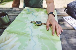 Explorer Planning Path using Map, Compass, Resting at Outdoors Table photo