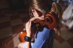 Young Musician Practicing the Cello in a Harmonious and Focused Home Environment photo