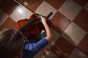 Overhead View of a Person Playing Cello on Tiled Floor photo