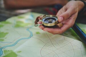 Traveler Holding a Compass Over a Map Highlights Navigation and Exploration photo