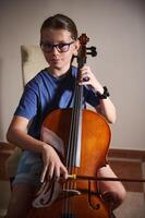 Young Cellist Playing Cello in a Home Environment with Focused Expression photo