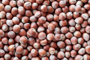 Close-up, many hazelnuts scattered across the surface create a textured food background to showcase food concepts such as healthy eating, snacking, and large harvest photo