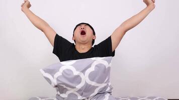 Asian man wake up and hugging pillow yawn and sleepy on white isolated video