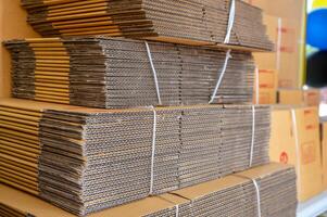 Stack of brown folded cardboard boxes tied photo