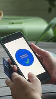Vertical . Person paying online using smartphone and bank credit card. Payment received text on phone screen. video