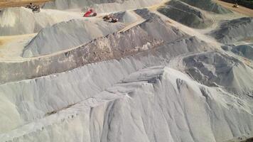 Aerial view of quarry with large piles of gravel and sand, heavy machinery working at mining site. video