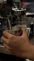 Barista is using high pressure steam operated milk frother to make frothed foam video