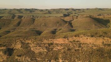 Aerial view Kakheti region Georgia at sunset showing green rolling hills canyons and rugged terrain with warm light and seasonal vegetation video