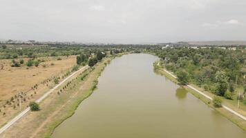 Aerial panning view of Rustavi Central Park featuring a calm lake surrounded by trees and walking paths, popular for recreation cycling and nature enjoyment in Georgia video