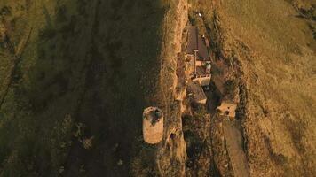 Aerial top view of an ancient stone watchtower standing alone on a remote ridge in David Gareja, Georgia, symbolizing medieval defense, isolation, and border vigilance. video