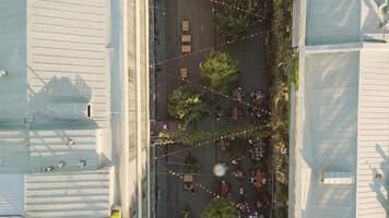 Tbilisi, Georgia - 1st july, 2025- Aerial Fabrika courtyard in Tbilisi, vibrant social hub with outdoor seating, trees, string lights, groups of guests enjoying the lively atmosphere in heart of city video