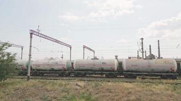 Rustavi, Georgia - 2025 - Freight train with Texol tanker wagons moves past large Rustavi industrial complex, with smokestacks, cooling towers, and visible environmental impact in background. video