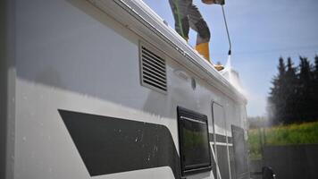 Cleaning a Campervan Exterior With Water and Soap in a Sunny Outdoor Setting video