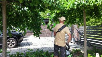 Gardener Pruning Trees in a Residential Yard During Sunny Day video