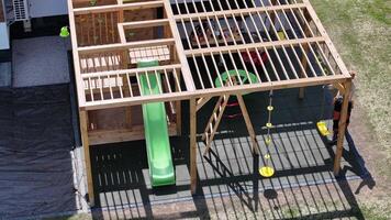 Wooden Play Structure With Slide and Swings for Outdoor Fun in Residential Backyard video