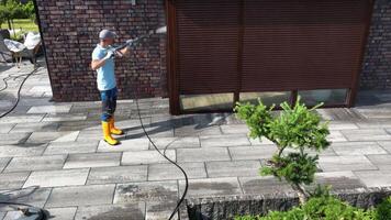 Homeowner Cleans Patio Using Pressure Washer in Sunny Backyard Setting video