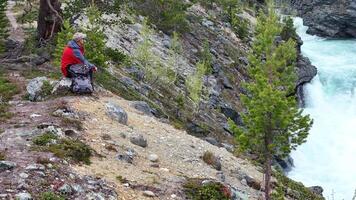 Exploring Norwegian Nature by the Rushing River With Hiking Gear Beside Rocky Terrain video