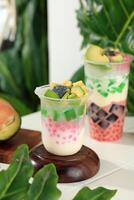 Es Teler Sultan in Tall Plastic Cup, Indonesian Traditional Mix Fruit on White Table photo