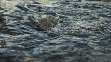 A closeup view of bubbling water, beautifully reflecting light and creating unique textures throughout video
