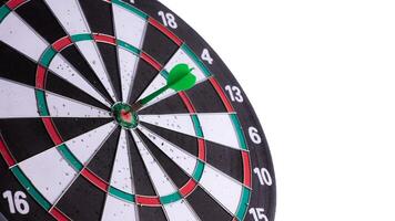 Green dart hitting bullseye on dartboard with white background and negative space. Business target, precision, focus, accuracy, success concept. Isolated goal achievement symbol. photo