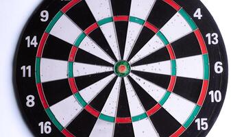 Close up of dartboard bullseye on white background. Focus and precision concept, target for darts game, competition, success, strategy, goal achievement. Isolated sports equipment. photo